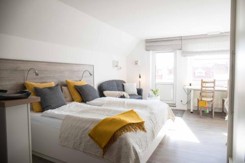 诺德奈Villa Westend的白色卧室配有一张带黄色毯子的大床