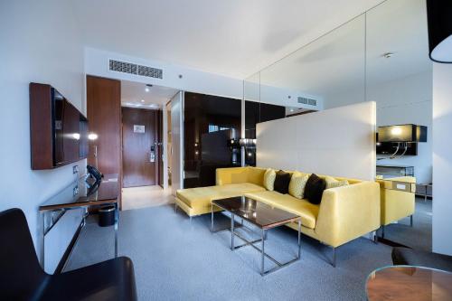 多哈多哈首府中心罗塔纳酒店的客厅配有黄色的沙发和桌子