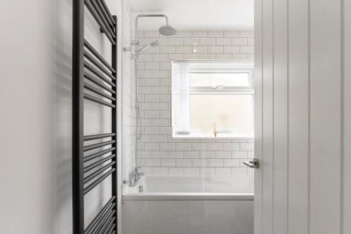 查尔伯里Quiet Cotswold Bungalow的白色的浴室设有浴缸和窗户。