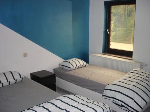 Courcellesappartement Courcelles的一间卧室设有两张床和窗户。