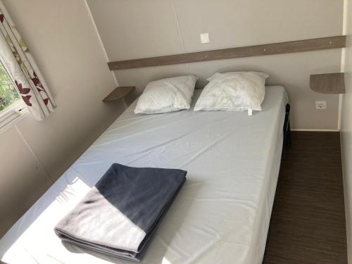 La Boissière-de-MontaiguMobile home 3 chambres Camping Cœur de Vendée 3 étoiles的一张带白色床单和枕头的床