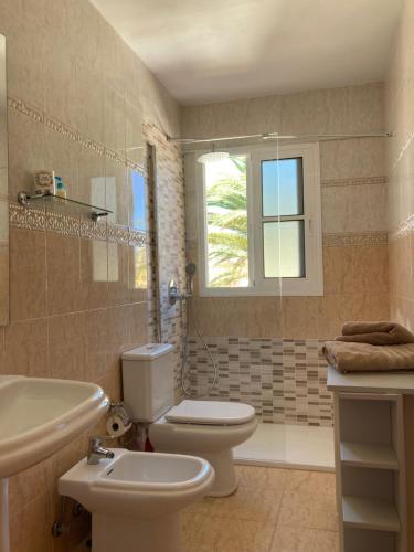卡勒达德福斯特Las Rocas Golf and Sea的一间带卫生间、水槽和窗户的浴室