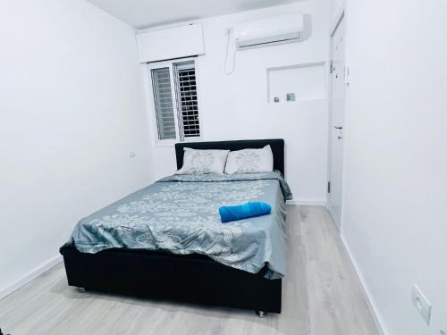 巴特亚姆New! Your home in Israel Luxury Suite的一间白色的卧室,床上有蓝色的管子