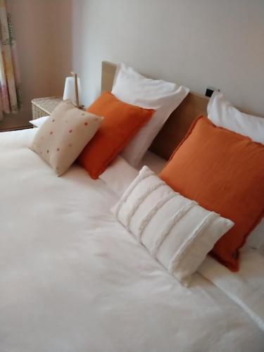 迪南'Nulle Part Ailleurs'的白色的床和橙色及白色的枕头
