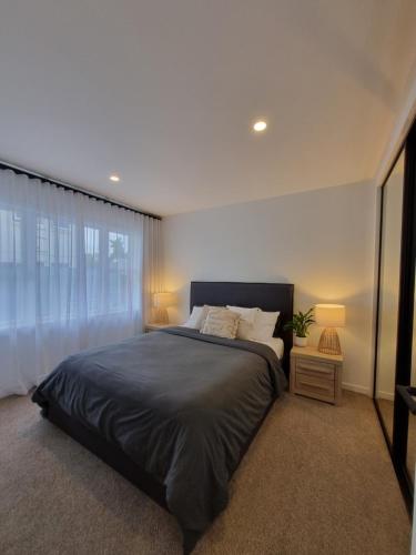 汉密尔顿Inner City 2 Bedroom Unit的一间卧室设有一张大床和一个窗户。