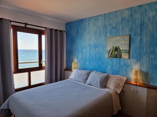 托里代巴拉Apartamentos Wundermar的一间卧室配有一张蓝色墙壁的床
