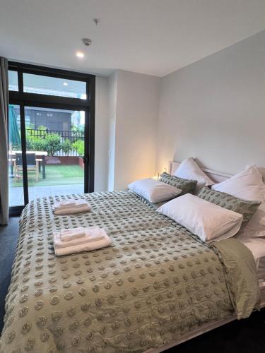 奥克兰3 bedroom apartment in Newmarket的一间卧室配有一张大床和两条毛巾