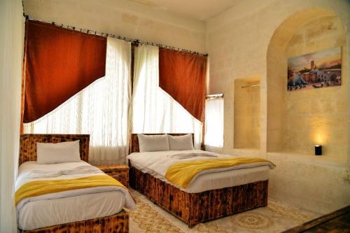 尚勒乌尔法karagül otel的一间卧室设有两张床和窗户。