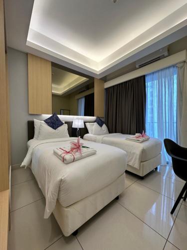 云顶高原Genting @ The MOST by NextGen的酒店客房,配有两张带粉红色弓的床铺
