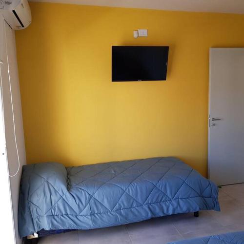 圣路易斯Dpto. San Luis Zona Shopping/centro的一间卧室设有蓝色的床和黄色的墙壁