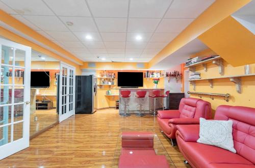 门罗Villa Verde B&B, bsm, Greenwood Lake, NY的一间带红色沙发的客厅和一间酒吧