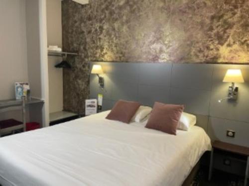 里摩日Kyriad Direct Limoges Nord的卧室配有一张带两个枕头的大白色床