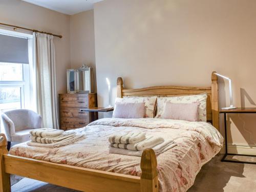 CrosskeysCwmcarn Cottage的卧室配有床、椅子和窗户。