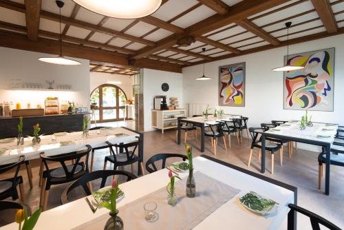特里滕海姆Moselweingut & Gästehaus Hubertushof的一间在房间内配有桌椅的餐厅