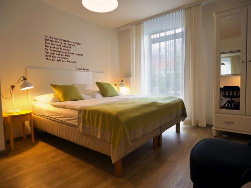 格拉茨吕克特别墅酒店的一间卧室设有一张床和一个大窗户