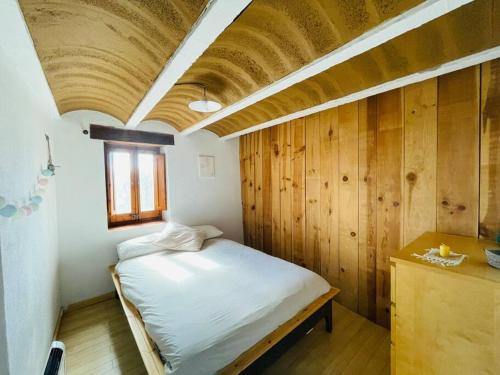 Cal Megui的一间卧室设有一张木天花板床。