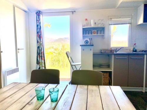 塔里法Cozy cottage in nature, with Garden and Sea View & Fast 350mbps Wi-Fi的厨房配有木桌、两把椅子和一张桌子。