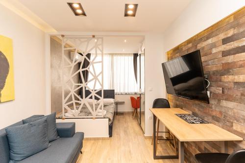 塞萨洛尼基Valaoritou Luxury Studio的带沙发、桌子和电视的客厅