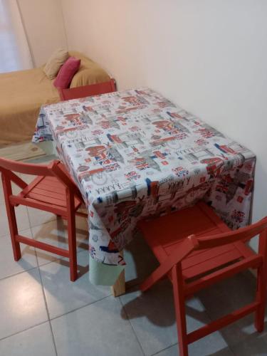 罗萨里奥Departamento MyF的一张桌子和两把椅子,上面有被子