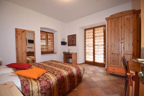 罗韦雷托RAINBOW的一间卧室配有一张带橙色枕头的床