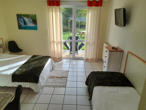 LangeacHotel de l'Ile d'Amour的一间卧室设有两张床和滑动玻璃门