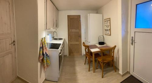 埃斯比约Værelse med eget køkken og bad的一间带桌子和白色冰箱的小厨房
