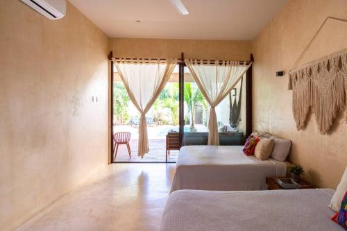 图卢姆Casa Esperanza Tulum Private Pool的一间卧室设有两张床,并设有一个通往庭院的门。