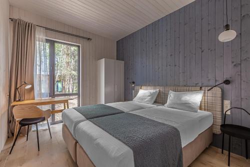 DzvinkoveЗаміський комплекс - DOGODA的一间卧室配有一张床、一张书桌和一个窗户。