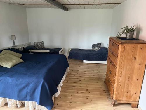 斯塔德Öja的一间卧室配有蓝色的床和木制梳妆台