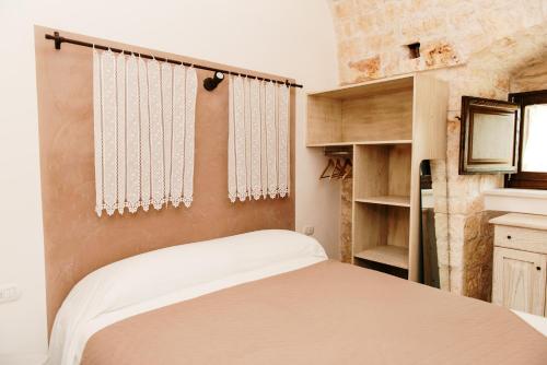 洛科罗通多Trulli delle Sete的一间带一张床和一个衣柜的小卧室