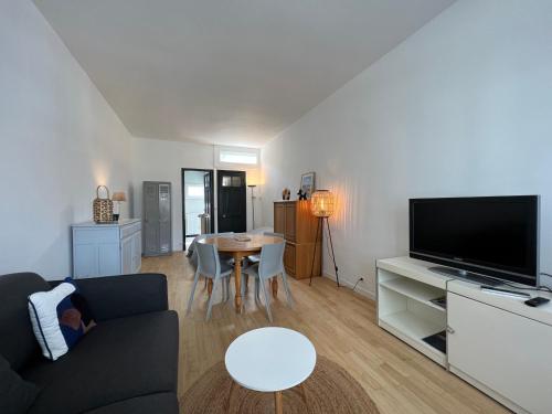 勒图凯-巴黎普拉日Petite maison de charme的带沙发、电视和桌子的客厅