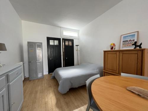 勒图凯-巴黎普拉日Petite maison de charme的一间卧室配有一张床和一张桌子