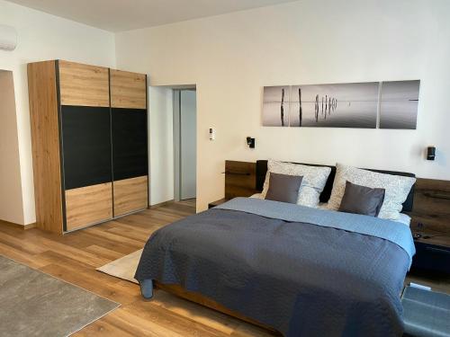 克塞洛Corner Apartman的一间卧室配有一张床和一个大型橱柜