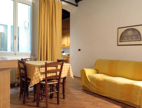 佛罗伦萨马茨第八公寓的客厅配有桌子和黄色沙发