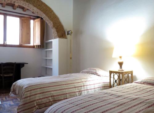 佛罗伦萨马茨第八公寓的一间卧室设有两张床和一张桌子上的台灯。