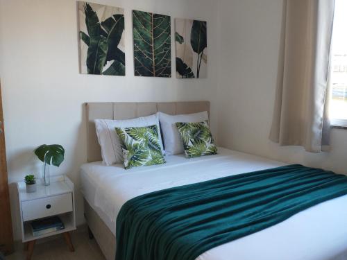 里约热内卢Espaço Acolhedor, Rio de Janeiro的一间卧室配有一张带绿床单和枕头的床。