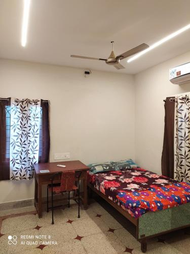 维沙卡帕特南Anve's Airport Nest的卧室配有床、桌子和窗户。