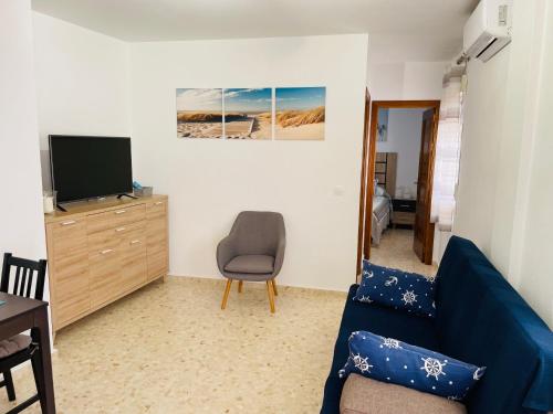 科尼尔-德拉弗龙特拉Apartamento Conil Playa & Centro, perfecto descanso, con Aire Acond y WIFI的客厅配有蓝色的沙发和电视