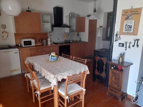 Rivalta ScriviaDa Mariuccia的一间带桌椅的厨房和一间带炉灶的厨房