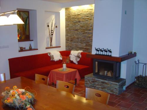 BobrŭvkaApartmánový dům Bobrůvka的客厅设有红色的沙发和壁炉