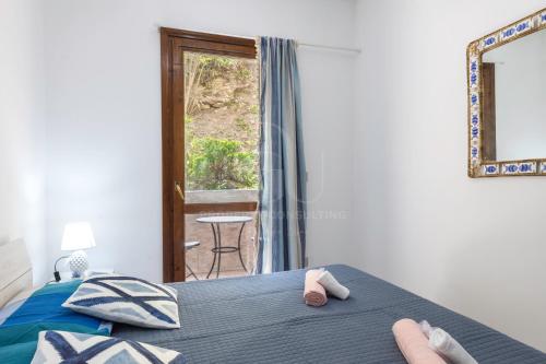 卡斯特尔萨多il gabbiano castelsardo的一间卧室配有一张床和一个带椅子的窗户