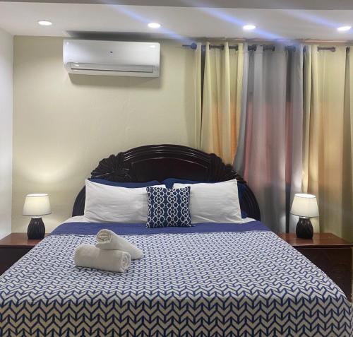 拉罗马纳Hotel Boutique Simona的一间卧室配有一张带两盏灯的蓝色和白色的床。