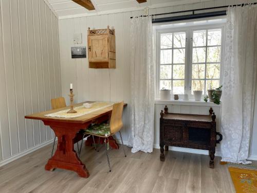 滕斯贝格Idyllic small farm appartment的一间带木桌和窗户的用餐室