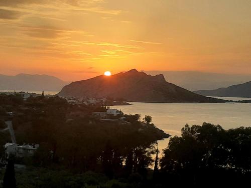 爱琴娜岛serenity villa Aegina fantastic view near the beach的山上和水中的日落