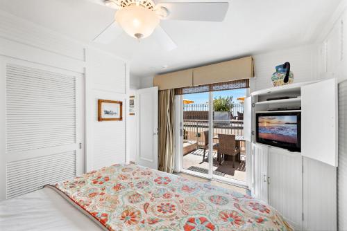 拉古纳海滩Villa Calypso的一间卧室配有一张床和一台平面电视