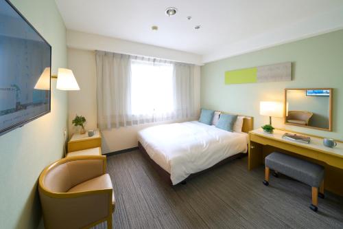 町田市町田市利索尔酒店的配有一张床和一张书桌的酒店客房