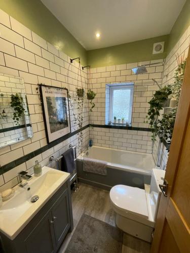 OxenhopeApple Street Cottage的带浴缸、盥洗盆和卫生间的浴室