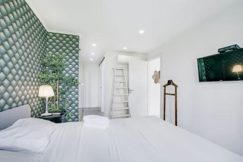 卡帕里卡海岸White and Light House的卧室配有白色的床和绿色的墙壁