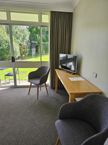 旺格努伊The Avenue的客房设有书桌、椅子和电视。