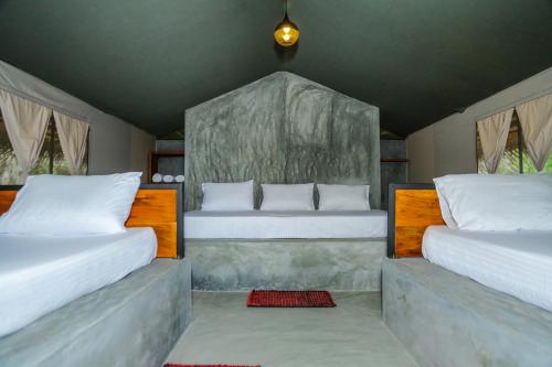 蒂瑟默哈拉默Yala Wild Hut - Yala的一间卧室配有两张带白色枕头的床